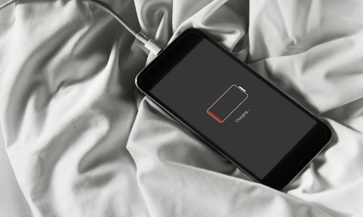 Battery Charger and Phone on the Bed